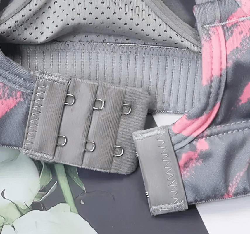 Close-up of double-row buckles on a stylish elastic sports bra with cross back, offering adjustable fit for comfort and support.